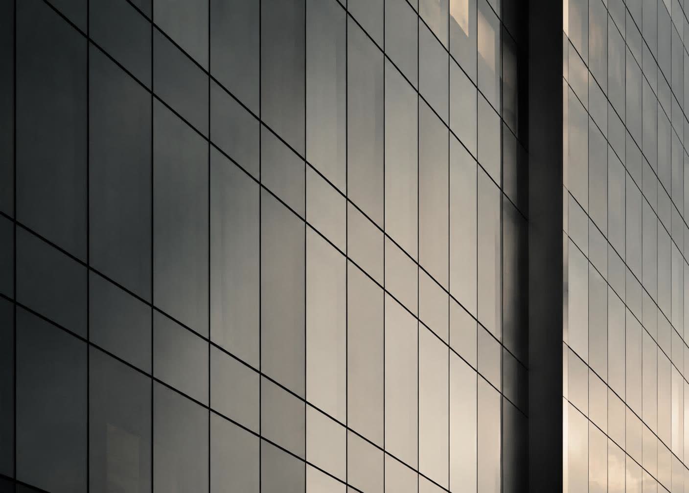 Grid of glass panels on a modern building facade at dusk